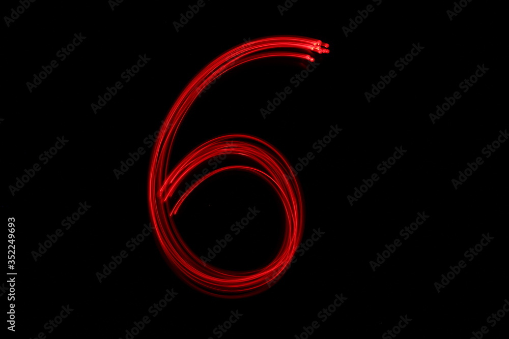 Long exposure photograph of the number 6 in neon red colour fairy lights against a black background. Light painting photography. Part of a number series. Long exposure photograph of the number 6 in neon red colour fairy lights against a black background. Light painting photography. Part of a number series.