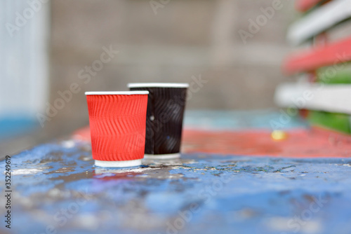 Empty paper cup red and black for coffee on the bench.