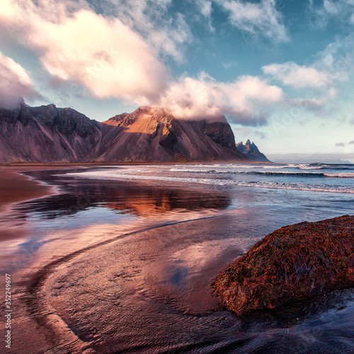 Icelandic Seascape. Famous Stokksnes cape and Vestrahorn Mountain with perfect sky during sunset in Iceland. Iconic location for landscape photographers. Amazing nature Scenery. Instagram style