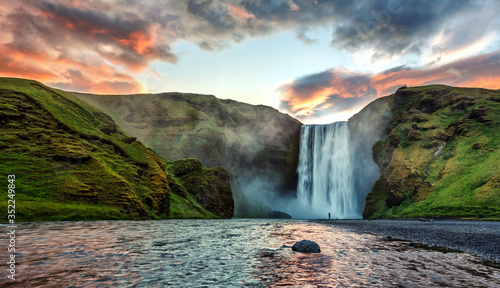 Impressive scenery of the majestic Skogafoss Waterfall of Iceland during sunrise. Amazing landscape with dramatic picturesque sky.  Iceland the most beautiful and best travel place. Beauty of World photo