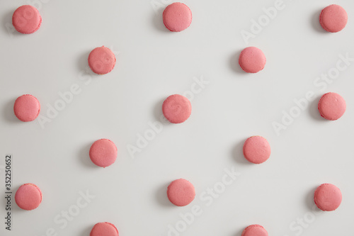 Sweet pink macarons to satisfy your sweet tooth isolated on white background. Delicious traditional French cuisine, can be consumed for breakfast with hot tea. Assorted cookies macaroons pattern