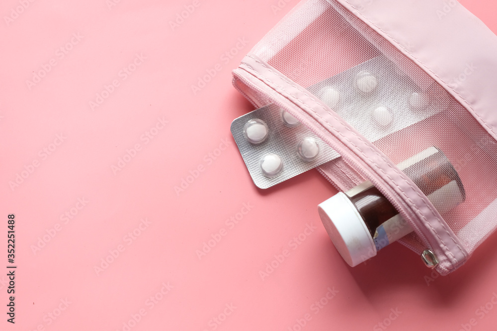 Top view of pill container and blister pack on pink 