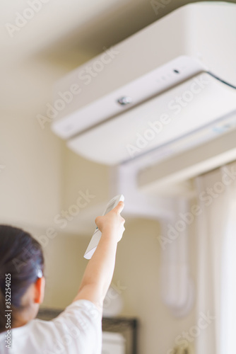 冷房　エアコン　温度調節　換気　夏　リモコン　リビング　人物　女性　日本人　ウィルス対策　空気清浄機