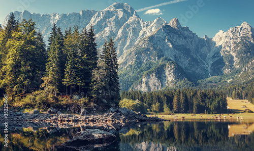 Lago di Fusine superiore near Tarvisio, Italy. Beautiful morning view of famous Superior Fusine Lake with Mount Mangart in the background at sunrise