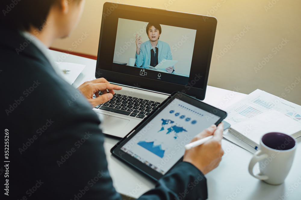 businessman working by video meeting according to quarantine period. Study or work at home by internet are useful for connection with social distancing prevent pandemic of coronavirus (covid-19). businessman working by video meeting according to quarantine period. Study or work at home by internet are useful for connection with social distancing prevent pandemic of coronavirus (covid-19).