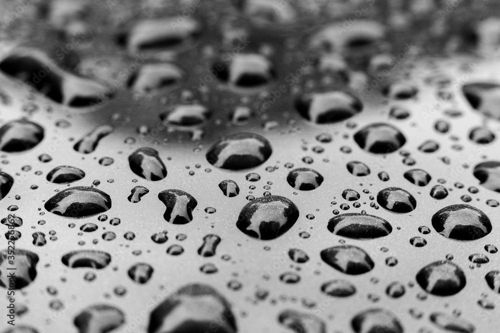 Raindrops on the roof of the car, black and white image, macro, selected focus
