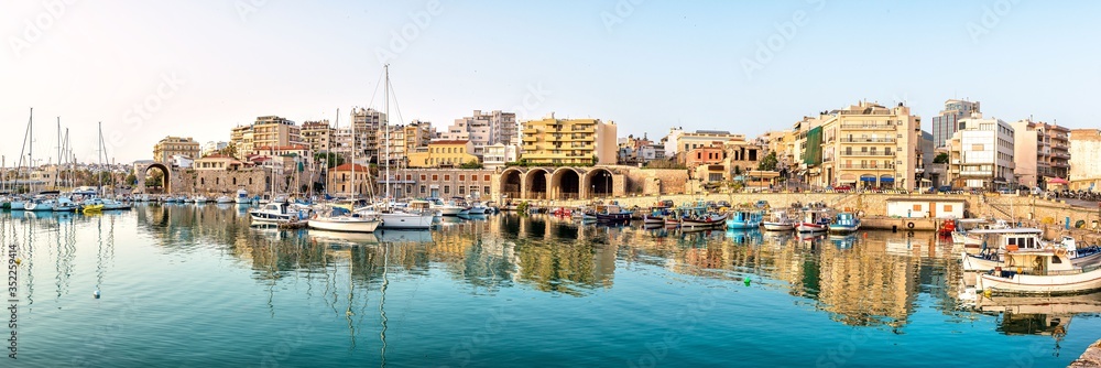 Panoramic photo of Heraklion in the early morning during sun rise, view to the old part of the town/city with its antient buildings and yaught port 
