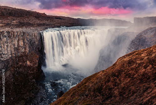 Dettifoss waterfall with dramatic colorful sky during sunset  Icelandic nature scenery Amazing long exposure scenery of famous landmark in Iceland. Creative image best locations for photographers