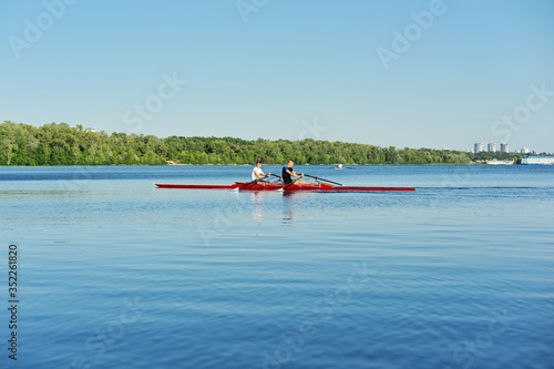 Team of two teenage boys kayaking on river