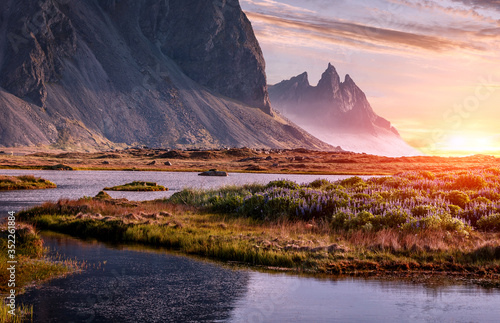 Scenic image of famous Stokksnes cape and Vestrahorn Mountain with colorful dramatic sky during sunset in Iceland. Iconic location for landscape photographers. Amazing nature of World.