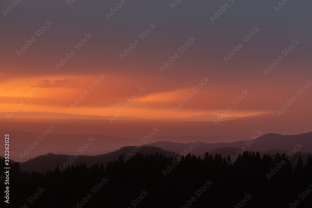 Sunrise landscape over carpathian mountain with orange sky in summer. Beautiful early morning mountain silhouette