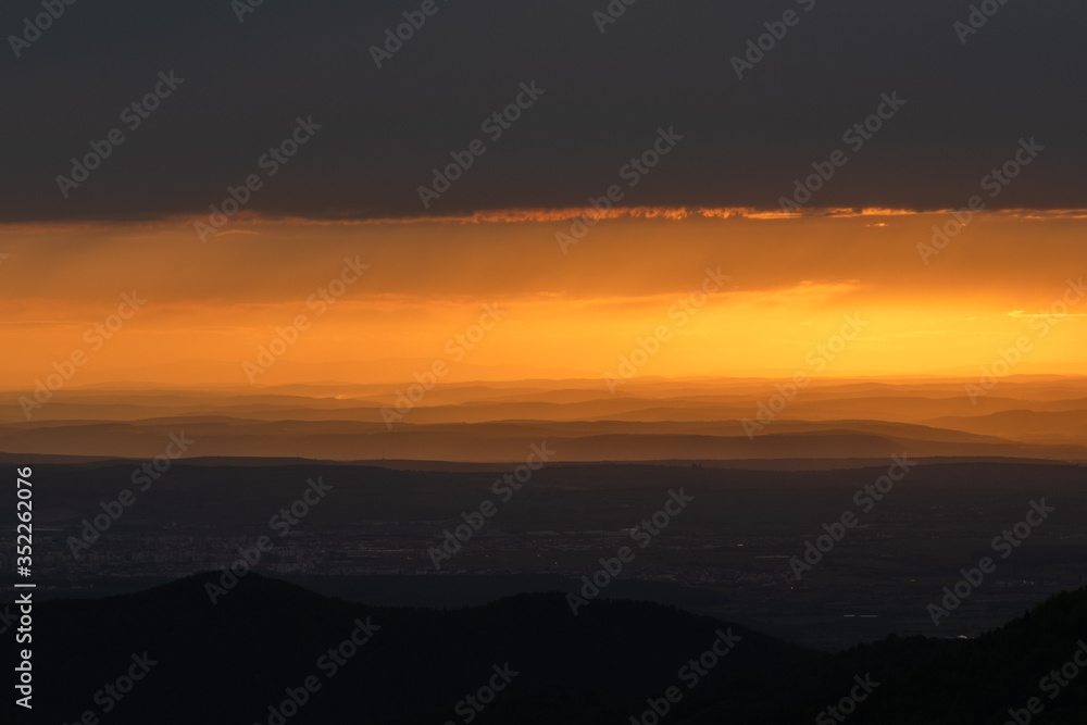 Beautiful sunrise landscape over Carpathian mountain. Early morning horizon with dark orange sky