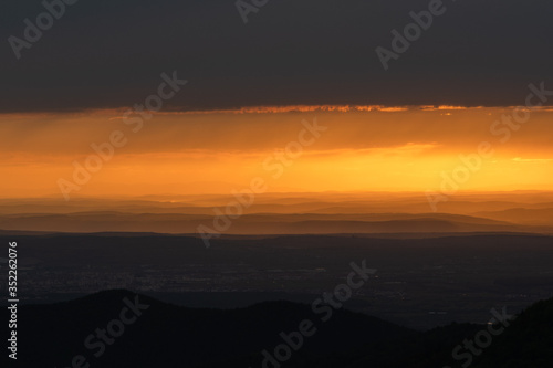 Beautiful sunrise landscape over Carpathian mountain. Early morning horizon with dark orange sky