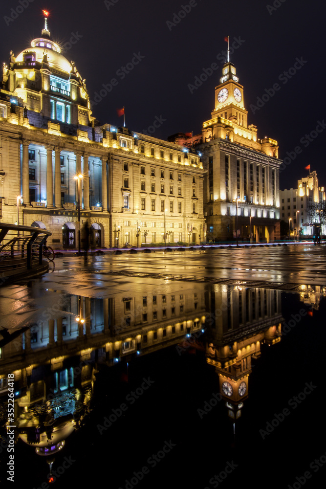 Fototapeta premium Historic building facades with red Chinese flags on top along Bund 