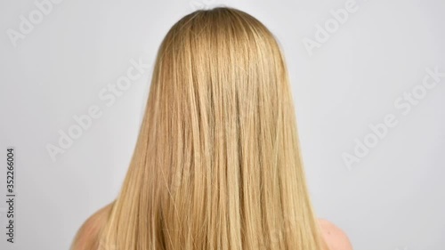 Haircare. Woman throws up hair. Beautiful healthy straight blonde hair.