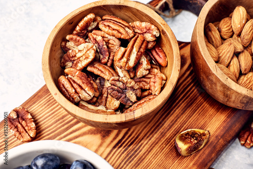 Peeled pecan nuts in the bowl on white background