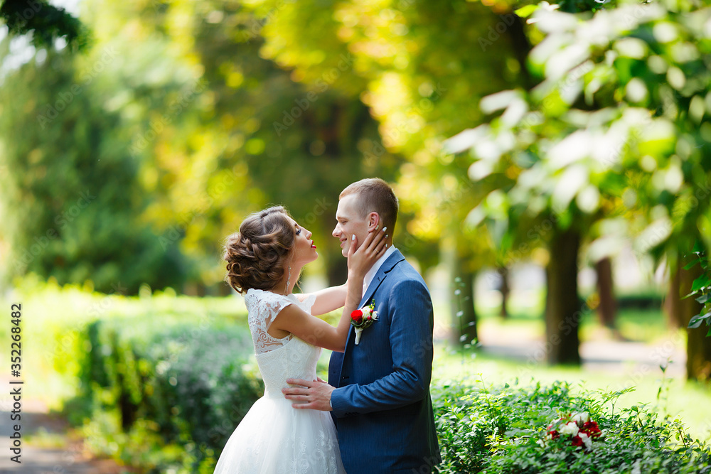 Elegant bride and groom posing together outdoors on a wedding day Elegant bride and groom posing together outdoors on a wedding day