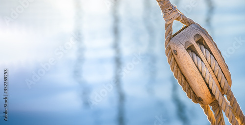 Sailing boat pulley, block and tackle with nautical rope. Nautic water panoramic background.