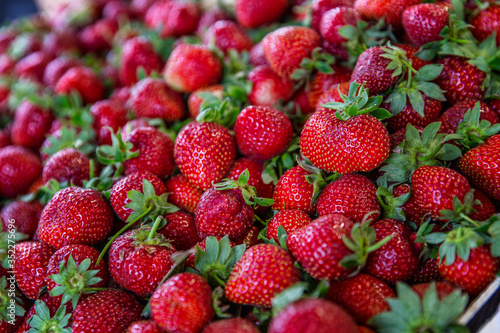 Ripe strawberries in the market. Healthy nutrition and vitamins. A lot of bright fragrant berries. Close-up.
