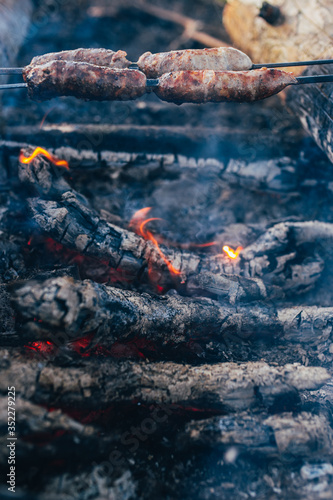 Wallpaper Mural Rustic sausage on a skewer at the stake - sausages are fried over an open fire in the forest - camping food Torontodigital.ca