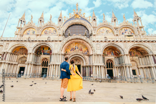 young pretty couple posing in front of saint marks basilica venice italy