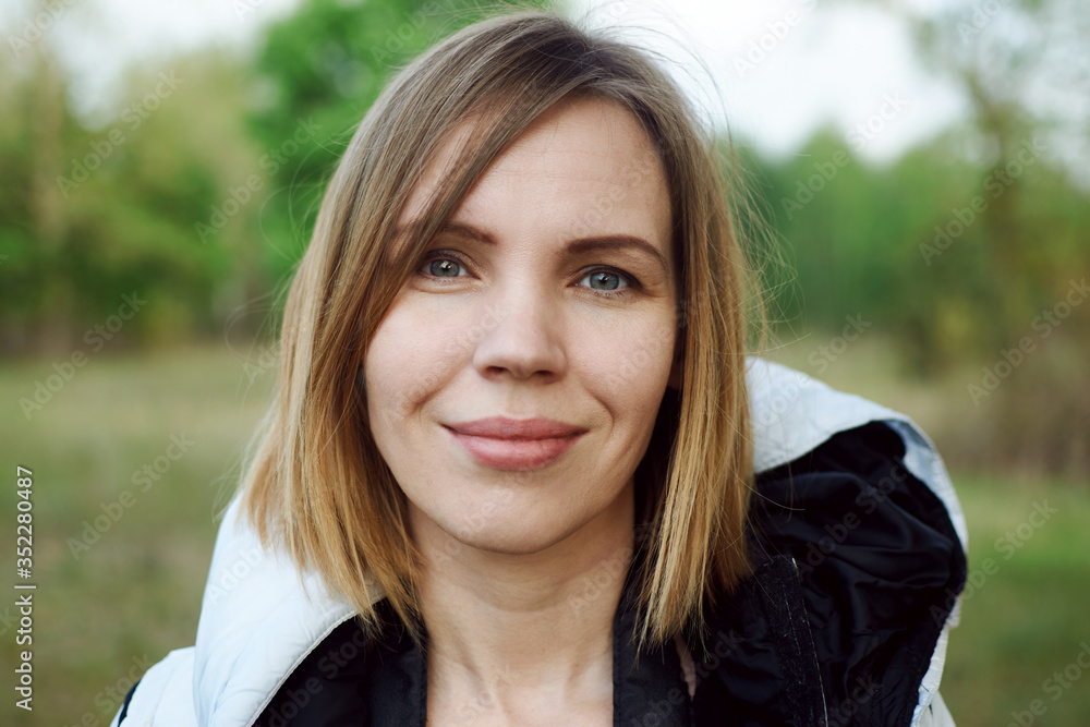 Middle-aged woman in a jacket on the street in the park. Middle-aged woman in a jacket on the street in the park.
