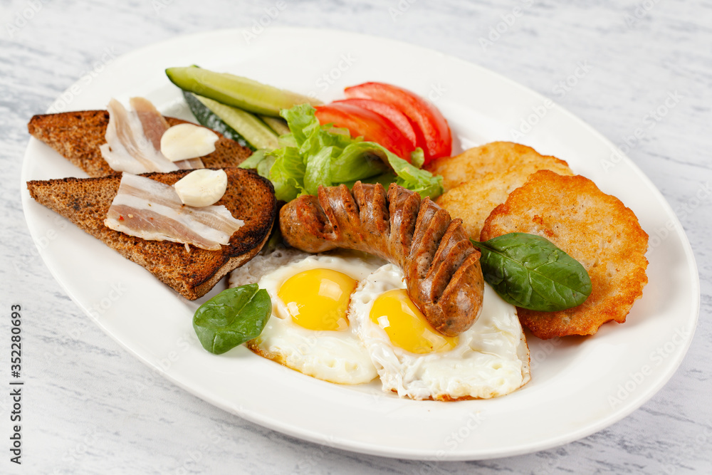 Hearty breakfast. Potato pancakes with sausage, fried egg Hearty breakfast. Potato pancakes with sausage, fried egg