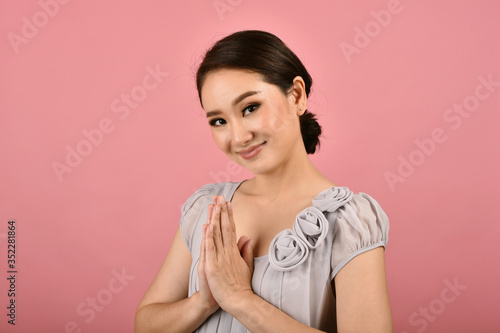 Thai asian smiling woman pay respect with wai sign, Sawasdee symbol is thai greeting culture for hello or goodbye, Welcome expression and body gesture. photo