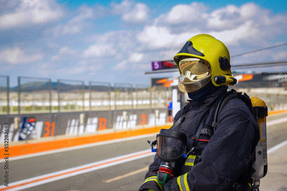 firefighter watching on race track during sporting event firefighter watching on race track during sporting event