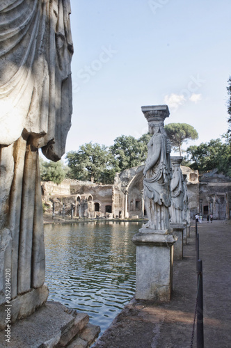 Garden photo. Ancient spartan sculpture with columns in italian park.