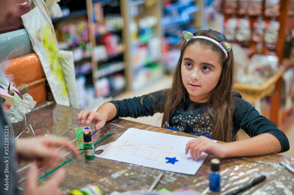 Fototapeta premium Young girl learning how to create mask. Children lab