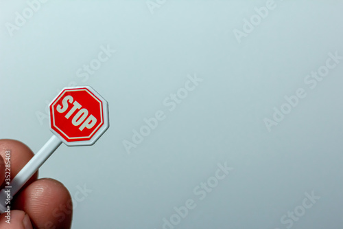 Red toy sign feet in a hand on a white background