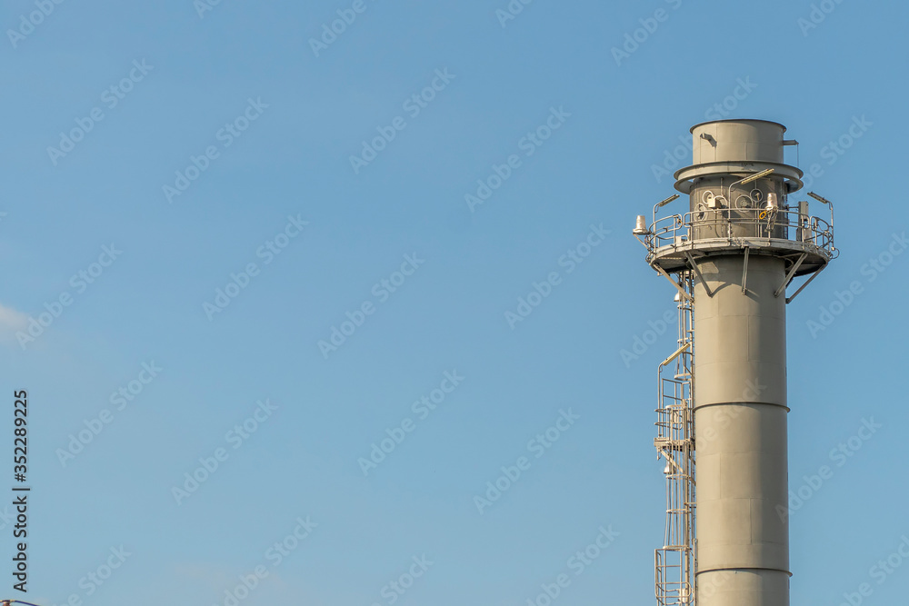 Electric plant chimney against the blue sky background, Power plant flue, copy space Electric plant chimney against the blue sky background, Power plant flue, copy space
