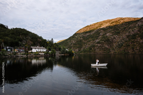 Wallpaper Mural Wedding couple standing hugging in a boat on the lake Torontodigital.ca