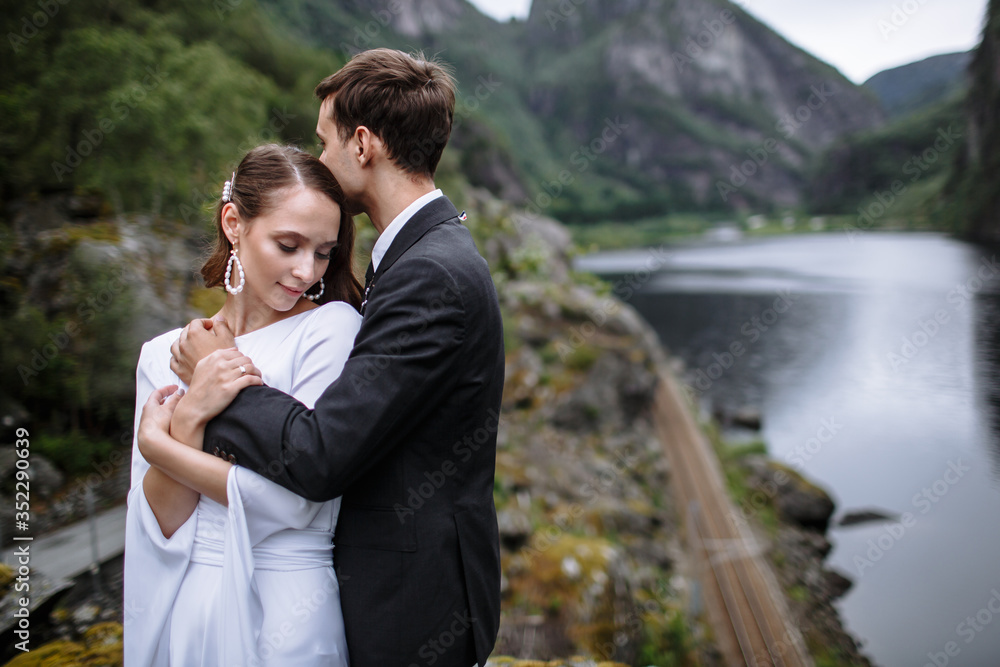 Wedding couple standing on a rock, against the background of the river