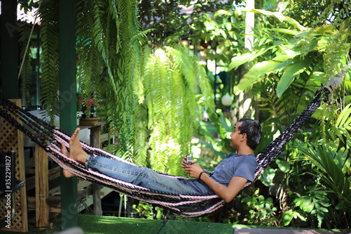 Man sitting in garden with green plants