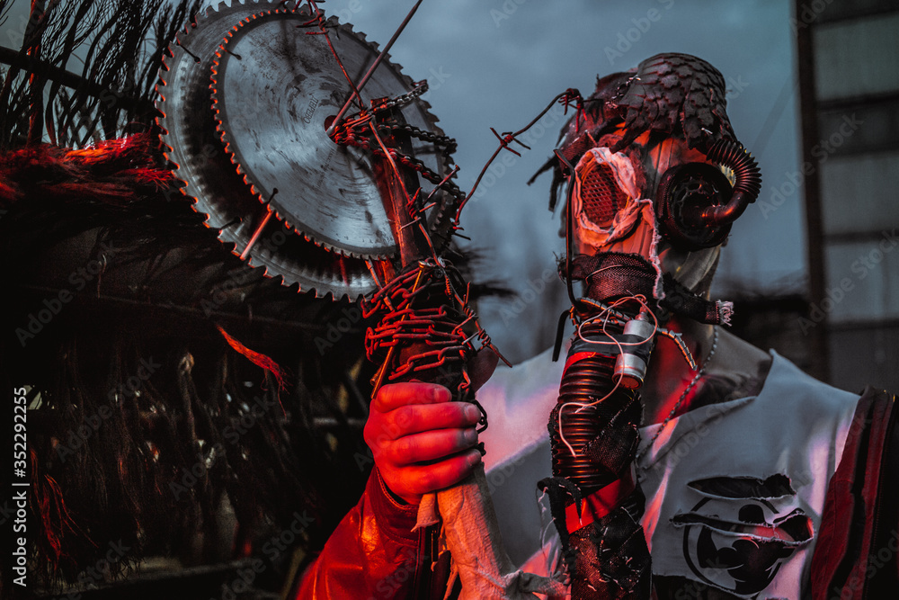 Fototapeta premium a young man in a factory during the Apocalypse in a castle and with a saw