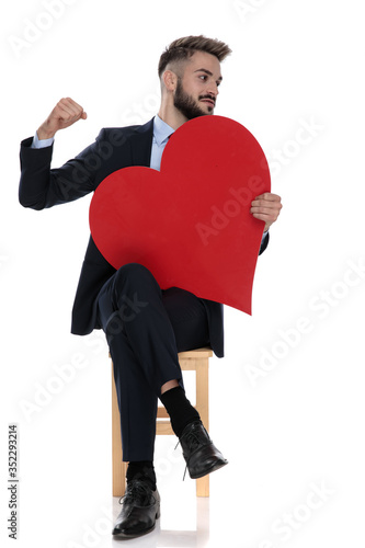 sexy young businessman holding big red heart and punching photo