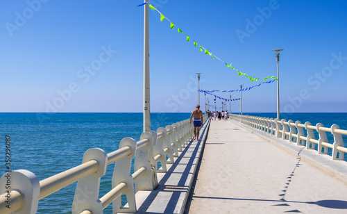 View of the pier of Forte dei Marmi with vacationers in a sunny summer day, Versilia coast, Tuscany, Italy