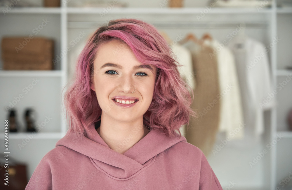 Happy hipster gen z teen girl fashion designer, stylist with pink hair and piercing wearing hoodie Happy hipster gen z teen girl fashion designer, stylist with pink hair and piercing wearing hoodie