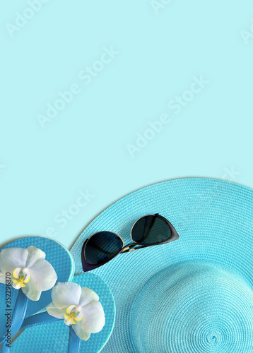 Summer hat with sunglasses. Top view, minimal concept over a blue background.