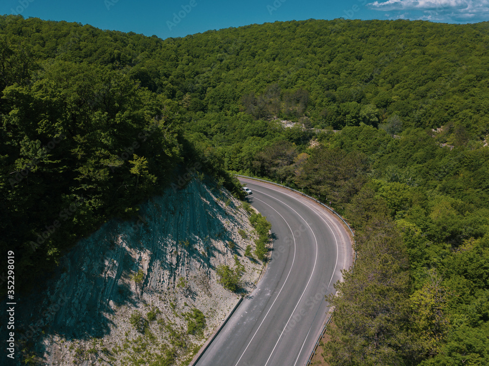 Mountain winding zig zag road. Top aerial view: cars driving on road from above.