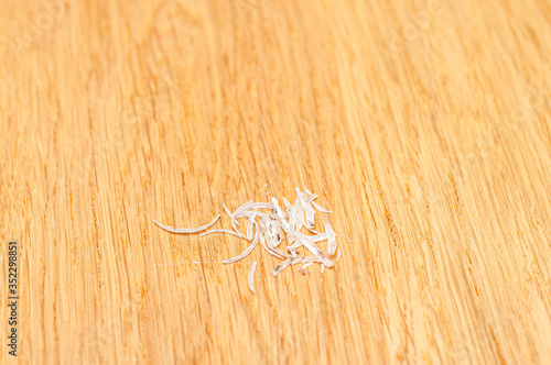 A small pile of cut human nails on a wooden background