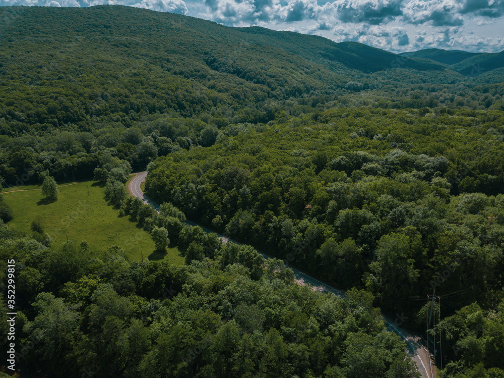 Obraz premium Aerial view of a rural highway between mountains