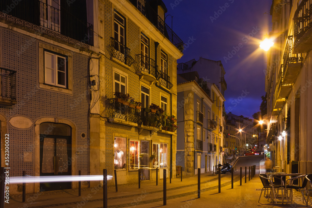 Lisbon city traditional home buildings on empty street at night. Long exposure photography in Portugal capital