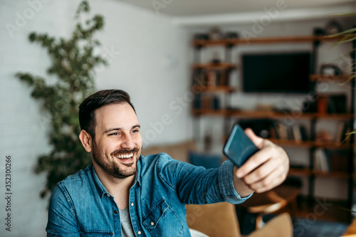 Handsome man taking a selfie on smart phone.