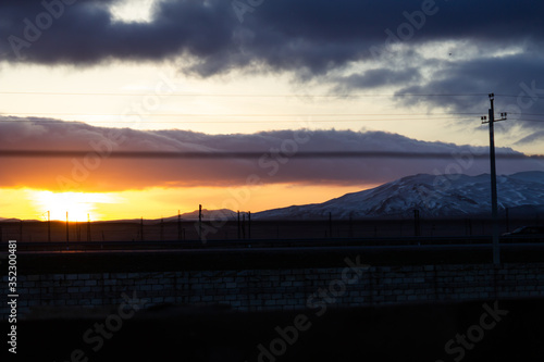 Mountain road on the way to the forest with sunset view