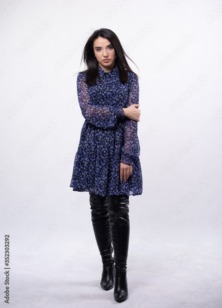 Happy beautiful woman in blue dress posing in studio isolated on white background,black long boots on his feet, Full length portrait Happy beautiful woman in blue dress posing in studio isolated on white background,black long boots on his feet, Full length portrait