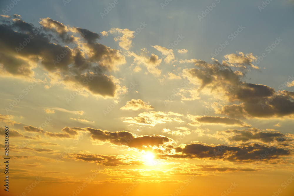 sunset sky with clouds and sunny beams
