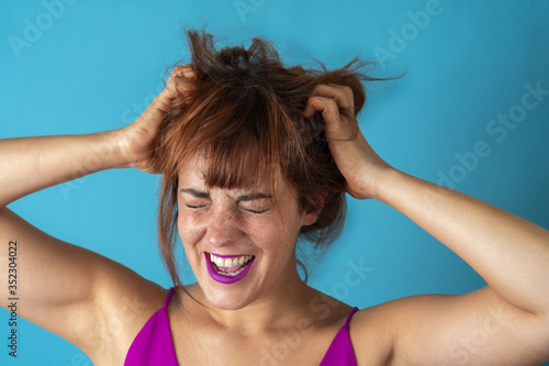 Stressed young woman pulling her hair while screaming